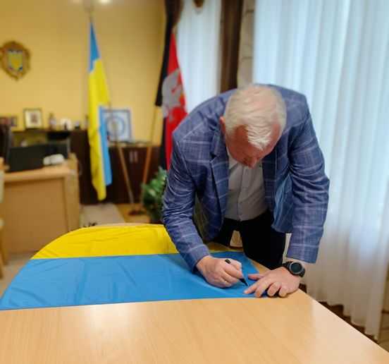 «Відважним та непереможним захисникам»,- підписуємо державні прапори з словами підтримки та побажаннями для воїнів із Львівщини